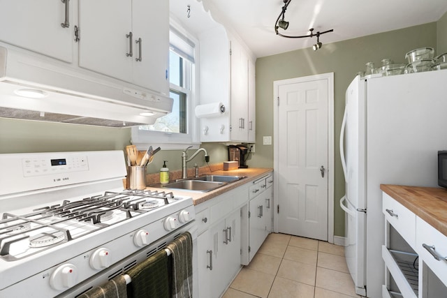 kitchen featuring a sink, under cabinet range hood, white appliances, and white cabinetry