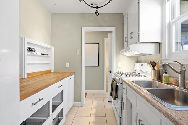 kitchen featuring gas range gas stove, a sink, white cabinets, under cabinet range hood, and light tile patterned flooring