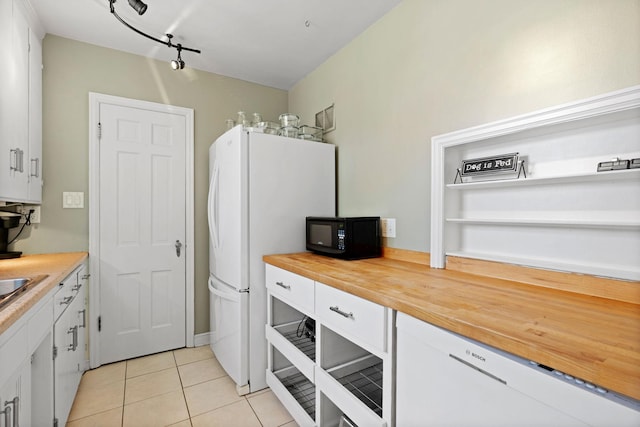 kitchen featuring white cabinetry, butcher block countertops, black microwave, and light tile patterned flooring