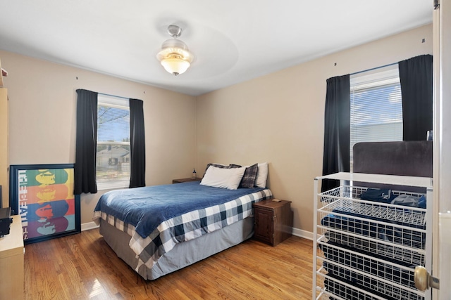 bedroom with baseboards and wood finished floors