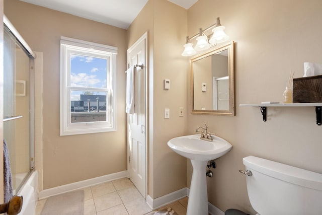 full bath featuring toilet, tile patterned floors, bathing tub / shower combination, and baseboards