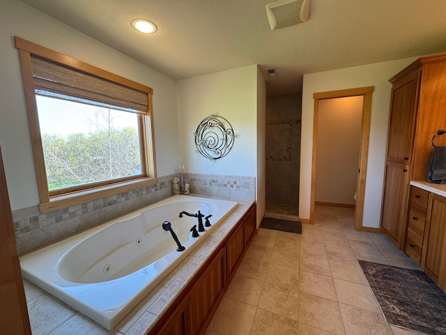 bathroom with a textured ceiling, visible vents, tile patterned flooring, a whirlpool tub, and tiled shower
