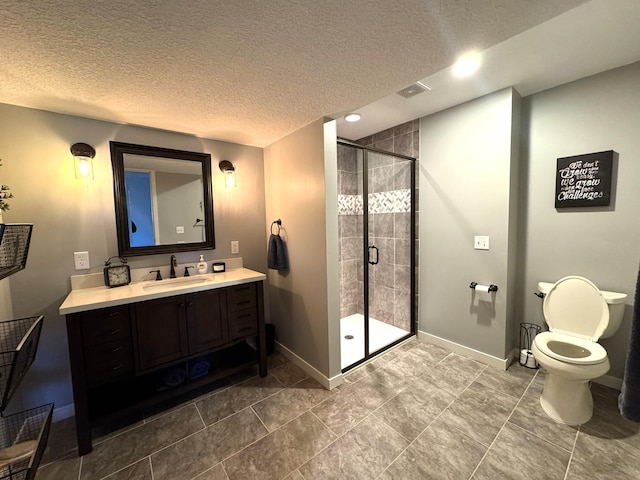 bathroom featuring vanity, a textured ceiling, baseboards, and a stall shower