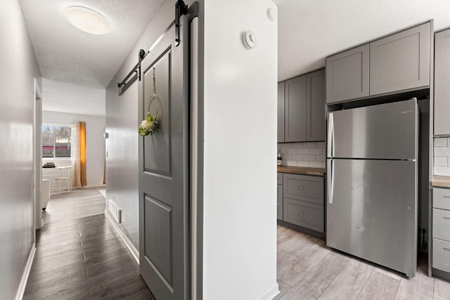 421 Robert St S, Saint Paul, MN 55107 - corridor with a textured ceiling, light wood-style flooring, a barn door, and baseboards