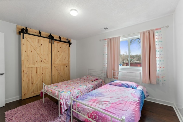 421 Robert St S, Saint Paul, MN 55107 - bedroom with a barn door, visible vents, wood finished floors, and baseboards