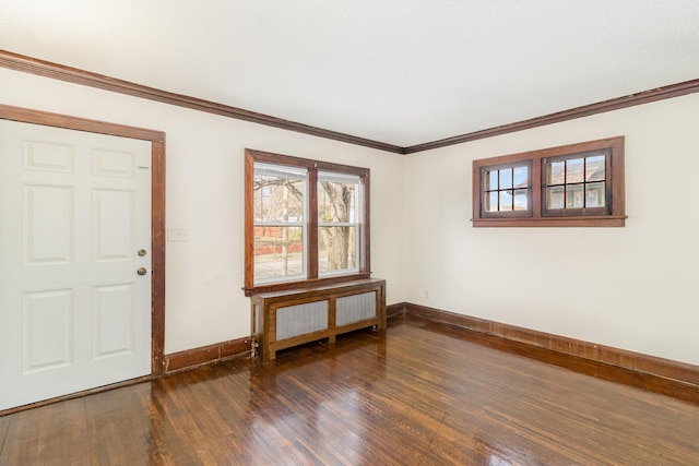 foyer featuring baseboards, radiator, dark wood-style flooring, and crown molding