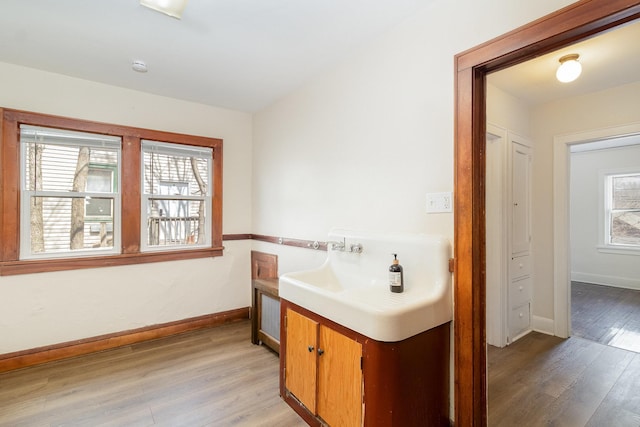 bathroom with vanity, wood finished floors, and baseboards