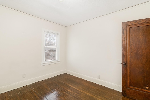 unfurnished room featuring dark wood-type flooring and baseboards