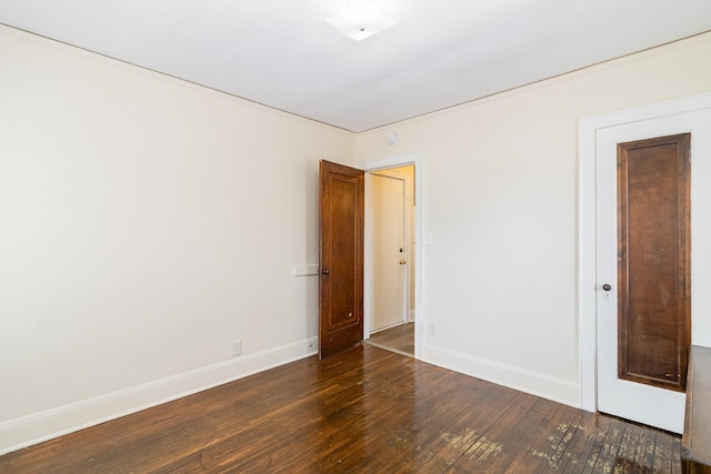 empty room featuring baseboards and wood finished floors