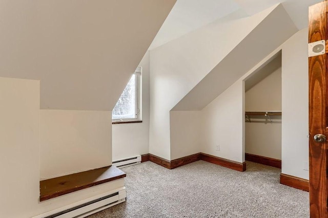 additional living space featuring baseboard heating, carpet flooring, and vaulted ceiling
