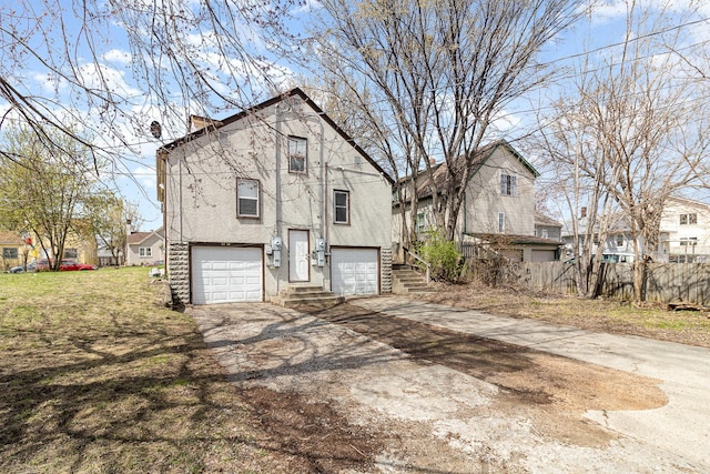 exterior space with stucco siding, driveway, a residential view, and an attached garage