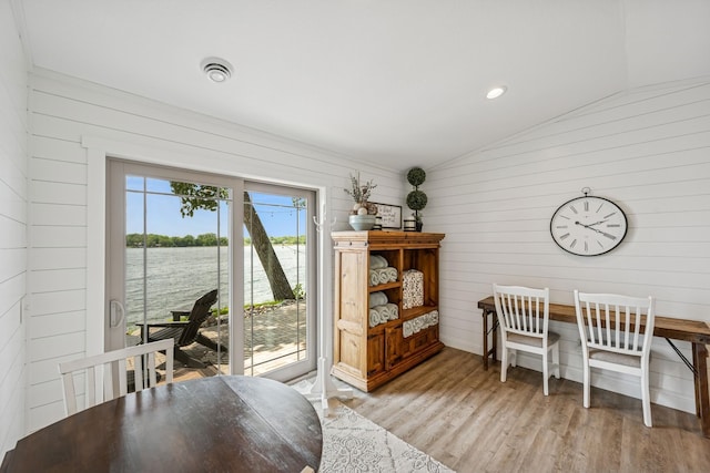 11831 Gulden Ave NW, Maple Lake, MN 55358 - dining room featuring lofted ceiling, wood walls, light wood-type flooring, and a water view