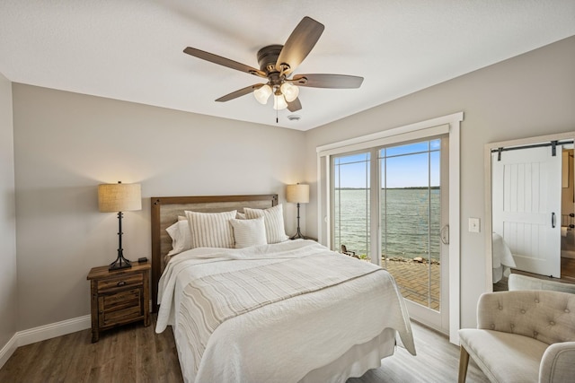 11831 Gulden Ave NW, Maple Lake, MN 55358 - bedroom featuring access to exterior, a barn door, wood finished floors, ceiling fan, and a water view