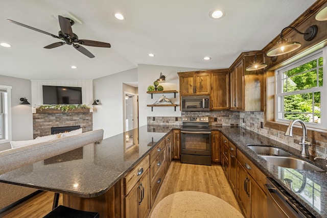 11831 Gulden Ave NW, Maple Lake, MN 55358 - kitchen with stainless steel appliances, open shelves, light wood-type flooring, vaulted ceiling, and a fireplace