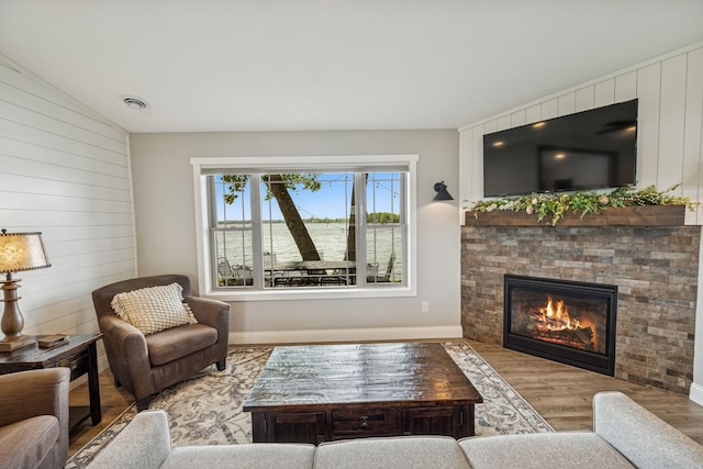 11831 Gulden Ave NW, Maple Lake, MN 55358 - living room featuring wood finished floors, wooden walls, and a glass covered fireplace