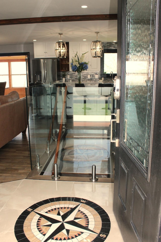 foyer entrance featuring recessed lighting, inlaid floor details, and a chandelier