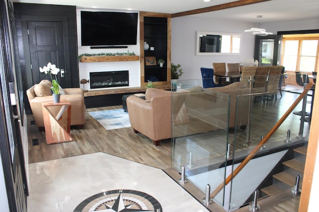 living room featuring wood finished floors, a large fireplace, and a chandelier