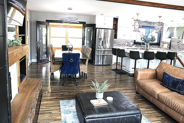 living area with dark wood-style flooring and baseboards