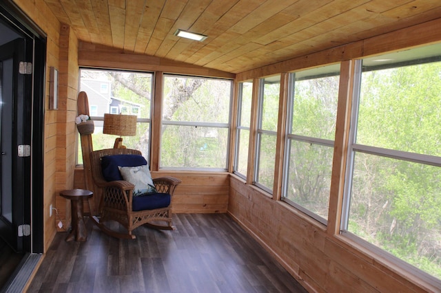 sunroom / solarium with wooden walls, wood finished floors, healthy amount of natural light, and vaulted ceiling