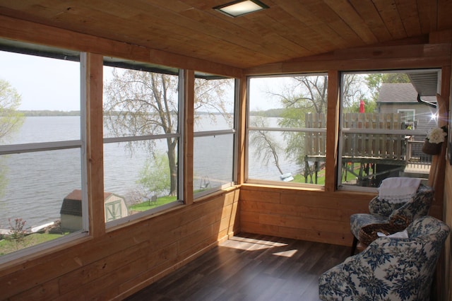 sunroom featuring a water view, wooden ceiling, wood finished floors, lofted ceiling, and wooden walls
