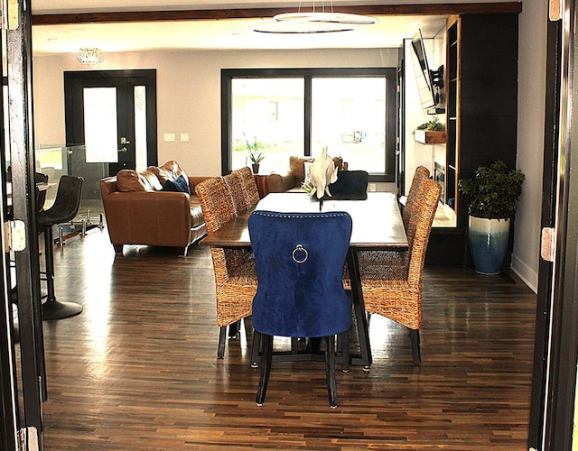 dining space with dark wood-style flooring and baseboards