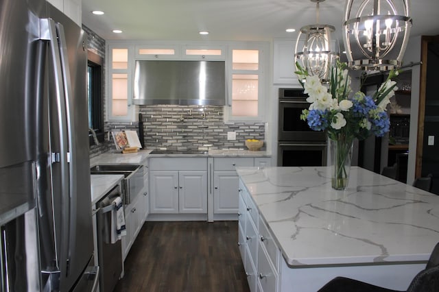 kitchen with stainless steel appliances, under cabinet range hood, a chandelier, white cabinets, and recessed lighting