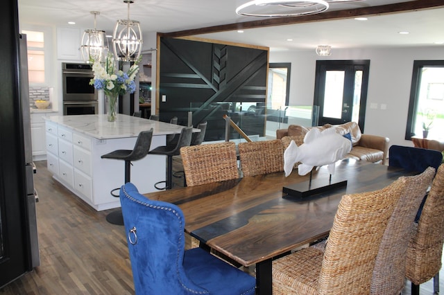 dining room featuring dark wood-type flooring, a chandelier, recessed lighting, and beam ceiling