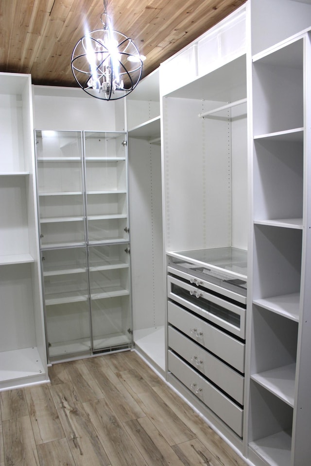 spacious closet featuring a chandelier and wood finished floors