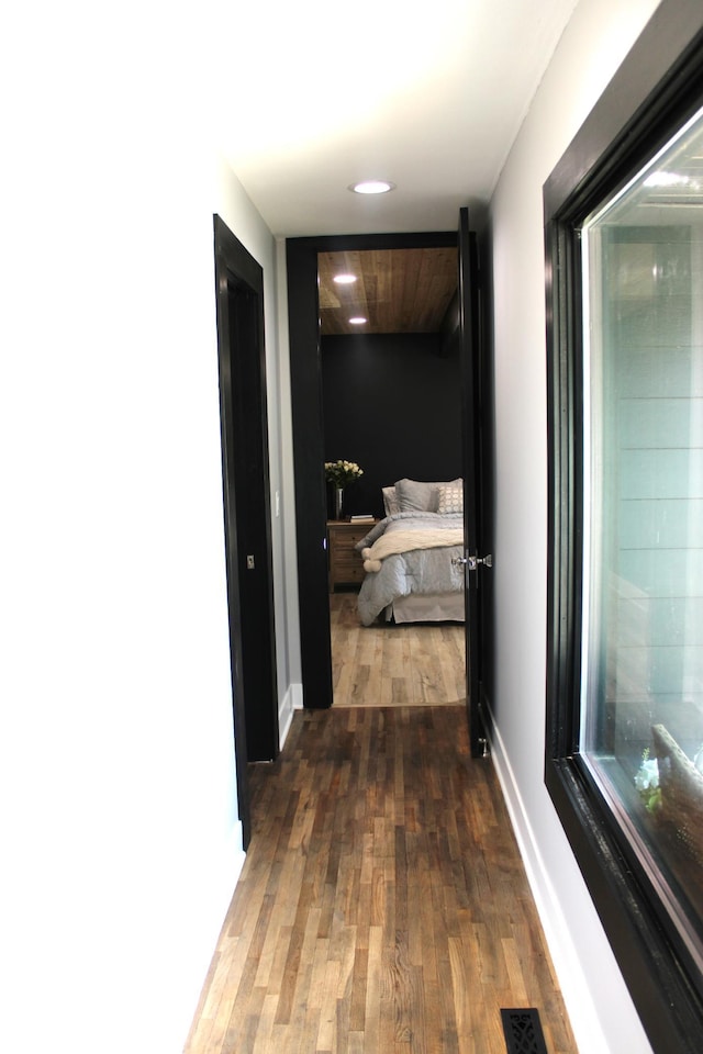 hall with wood finished floors, recessed lighting, and baseboards