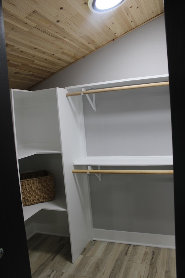 spacious closet with vaulted ceiling and wood finished floors