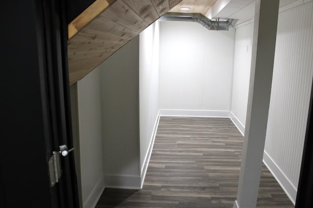 walk in closet with dark wood-style floors