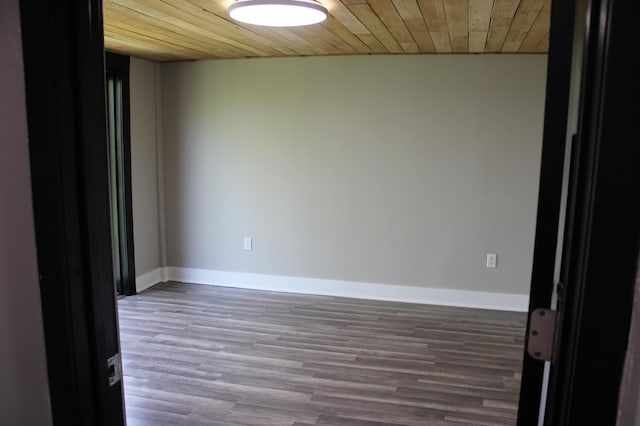 unfurnished room with wooden ceiling, wood finished floors, and baseboards