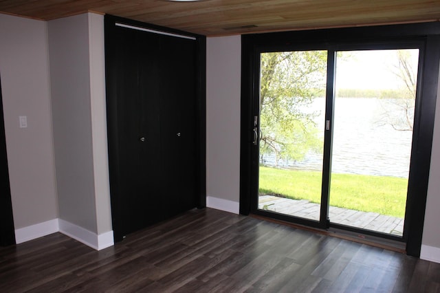 empty room featuring wood ceiling, dark wood finished floors, and baseboards