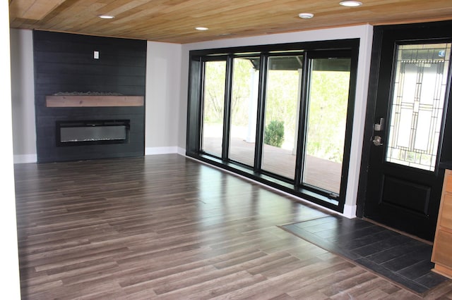 unfurnished living room featuring recessed lighting, a large fireplace, baseboards, wood finished floors, and wooden ceiling