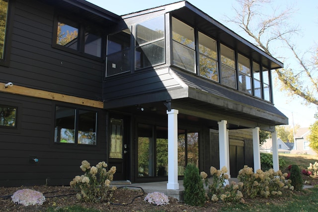 rear view of house featuring a sunroom