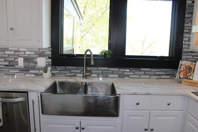 kitchen with a sink, backsplash, white cabinetry, and plenty of natural light