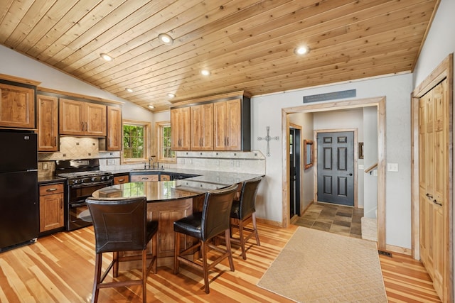 11847 Gulden Ave NW, Maple Lake, MN 55358 - kitchen with black appliances, vaulted ceiling, wood ceiling, a kitchen bar, and backsplash