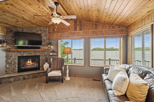 11847 Gulden Ave NW, Maple Lake, MN 55358 - living area with lofted ceiling, a stone fireplace, carpet, a ceiling fan, and wood walls