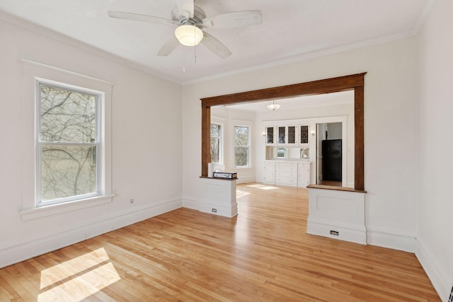 650 Pierce St NE, Minneapolis, MN 55413 - empty room featuring crown molding, baseboards, ceiling fan, and light wood finished floors