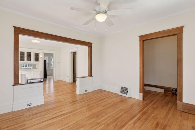 650 Pierce St NE, Minneapolis, MN 55413 - unfurnished room with visible vents, crown molding, baseboards, light wood-type flooring, and a ceiling fan