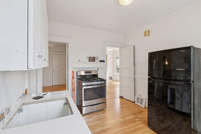 650 Pierce St NE, Minneapolis, MN 55413 - kitchen with a sink, stainless steel gas stove, light countertops, freestanding refrigerator, and visible vents