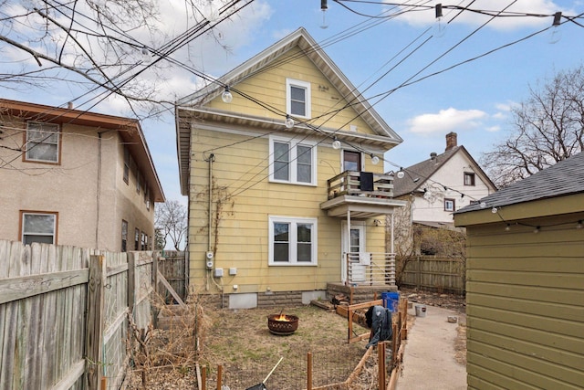 650 Pierce St NE, Minneapolis, MN 55413 - back of house with a fenced backyard, an outdoor fire pit, and a balcony