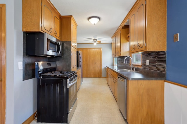 kitchen featuring decorative backsplash, a ceiling fan, appliances with stainless steel finishes, brown cabinets, and a sink