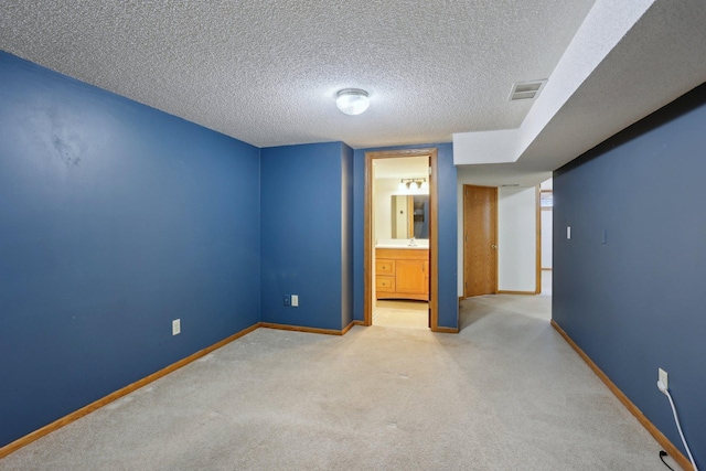 unfurnished bedroom with visible vents, ensuite bathroom, baseboards, a textured ceiling, and carpet flooring