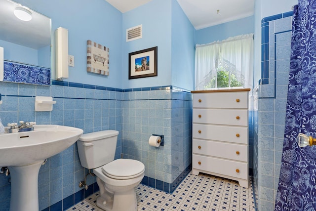 1804 Pinehurst Ave, Saint Paul, MN 55116 - bathroom with tile walls, tile patterned flooring, a wainscoted wall, and a shower with shower curtain