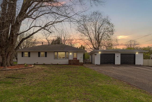 view of front facade featuring a yard, an outdoor structure, fence, and a garage