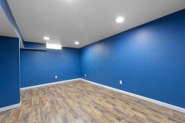 finished below grade area featuring recessed lighting, baseboards, and wood finished floors