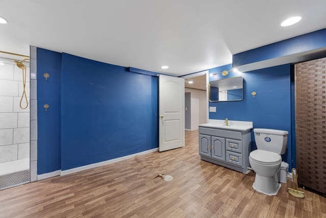 full bathroom with toilet, wood finished floors, vanity, recessed lighting, and a tile shower