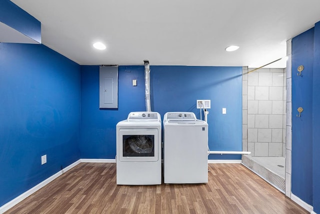 laundry area with electric panel, wood finished floors, laundry area, washer and dryer, and baseboards