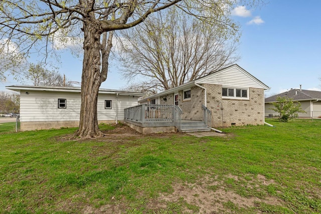 back of property featuring a yard, brick siding, crawl space, and a wooden deck
